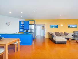 A kitchen and living room with a sofa and dining table at Whangamata