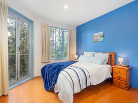 A bedroom with a bed and window at Whangamata in Whangamata