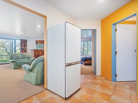A living room with a refrigerator and sofa at Whangamata