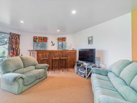 A living room with a bar and seating area at Whangamata
