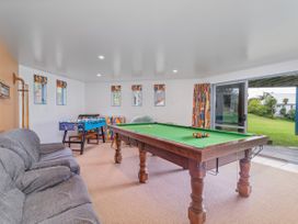A game room with a pool table and a foosball table at Whangamata