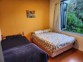 A bedroom with two beds and a window at The Tui’s View - Onemana Holiday Home, Onemana