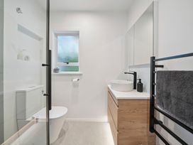 A bathroom with a sink, toilet, and mirror at Khandallah Stays - Wellington Holiday home Wellington