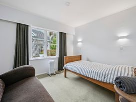 A bedroom with a single bed and a sofa at Khandallah Stays - Wellington Holiday home Wellington