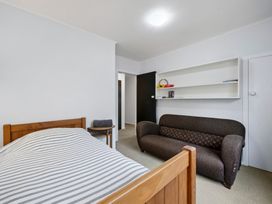 A bedroom with a bed and sofa at Khandallah Stays - Wellington Holiday home Wellington