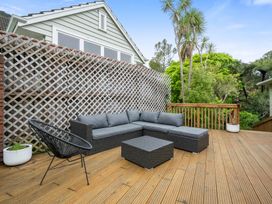 An outdoor patio with a sofa and coffee table at Khandallah Stays - Wellington
