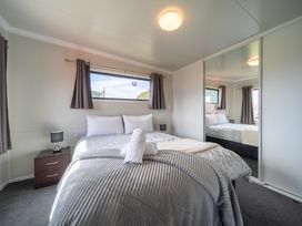 A bedroom with a bed and bedside table at Ducati House - Te anau Holiday Home