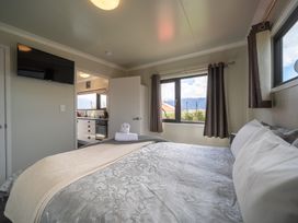A bedroom with a bed and television at Ducati House - Te anau Holiday Home