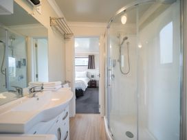 A bathroom with a sink and shower visible at Ducati House - Te anau Holiday Home