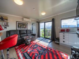 A living room with a sofa and kitchen area at Ducati House - Te anau Holiday Home