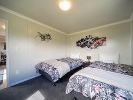 A bedroom with two beds and wall art at Ducati House - Te anau Holiday Home
