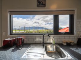 A kitchen with a sink and window looking outside at Ducati House - Te anau Holiday Home