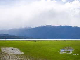 A landscape view featuring mountains, lake, and grassy field at Ducati House - Te anau Holiday Home