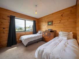 A bedroom with two beds and a window at The Back Hut - Te Anau Holiday Home Te Anau