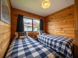 A bedroom with two beds and a window at The Back Hut - Te Anau Holiday Home in Te Anau