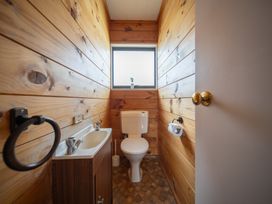 A bathroom with a toilet and sink at The Back Hut - Te Anau Holiday Home Te Anau