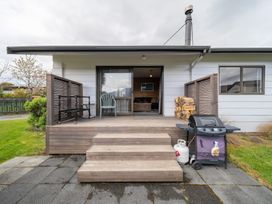 An outdoor deck with steps and a grill at The Back Hut - Te Anau Holiday Home Te Anau