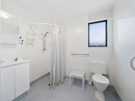 A bathroom with a shower, toilet, sink, and mirror at Kapiti Breeze - Waikanae Beach Holiday Home 