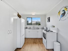 A kitchen with a refrigerator, stove, and sink at Kapiti Breeze - Waikanae Beach Holiday Home