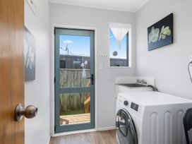 A laundry room with a washing machine and sink at Kapiti Breeze - Waikanae Beach Holiday Home