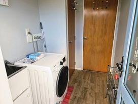 A laundry room with a washing machine and sink at Restful on Rutherford - Waikanae Beach