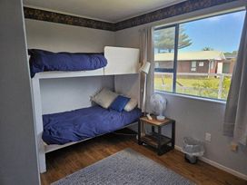 A bedroom with a bunk bed and a side table at Restful on Rutherford - Waikanae Holiday Home Waikanae Beach
