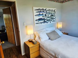 A bedroom with a bed and wall art at Restful on Rutherford - Waikanae Beach