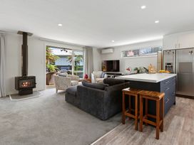 A living room with a fireplace and kitchen island at Rotorua Holiday Home in Rotorua