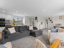 A living room with a sofa and dining area at Rotorua Holiday Home in Rotorua