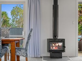A dining room with a wood stove and table at Rotorua Holiday Home in Rotorua