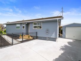 A house with a fence and steps at Rotorua Holiday Home in Rotorua