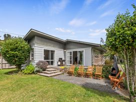 An outdoor area with chairs and a house at Lake Okareka Holiday Home in Rotorua