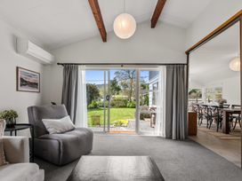 A living room with seating and a sliding door leading to a garden at Lake Okareka Holiday Home in Rotorua