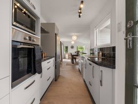 A kitchen with appliances and a view towards the dining area at Lake Okareka Holiday Home in Rotorua