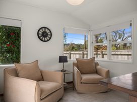 A snug with two armchairs and a lamp at Lake Okareka Holiday Home Rotorua