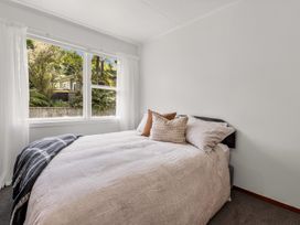 A bedroom with a bed and window at Lake Okareka Holiday Home in Rotorua