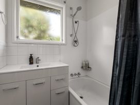 A bathroom with a bathtub, sink, and shower at Lake Okareka Holiday Home, Rotorua