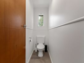 A bathroom with a toilet and a window at Lake Okareka Holiday Home Rotorua