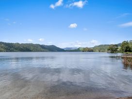 A lake surrounded by mountains and trees at Lake Okareka Holiday Home Rotorua