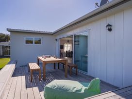 An outdoor seating area with a table and benches at Whangamata