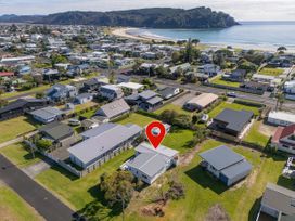 An aerial view of houses near a beach at Whangamata, Whangamata