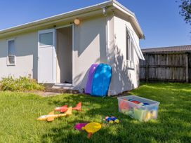 A garden area with beach toys and boogie boards at Whangamata