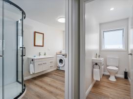 A bathroom with a shower, sink, and a toilet at Whangamata