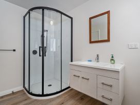 A bathroom with a shower and sink at Whangamata
