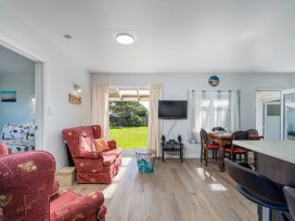 A living room with a sofa and television at Whangamata