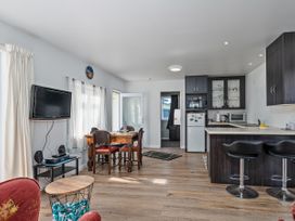 A dining room with a table and chairs at Whangamata