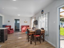 A dining room with a table and chairs at Whangamata
