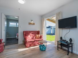 A living room with a sofa and television at Whangamata