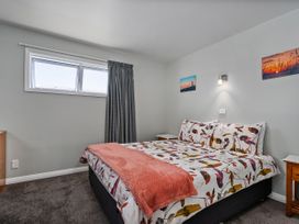 A bedroom with a bed and bedside table at Whangamata