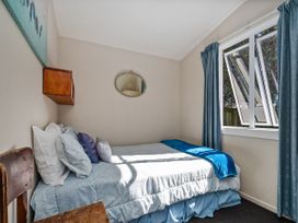 A bedroom with a bed and pillows at Whangamata in Whangamata